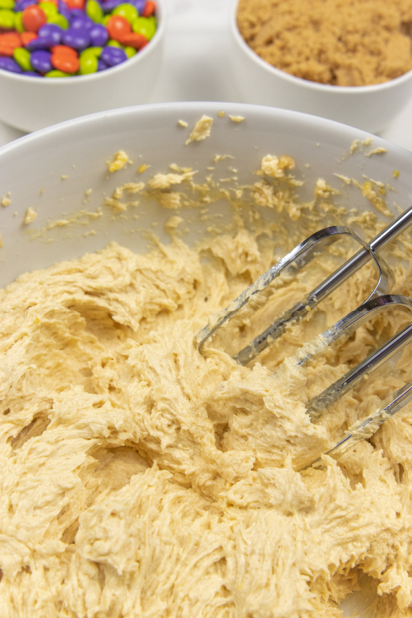 mixing up cookie batter in a bowl with hand mixer 
