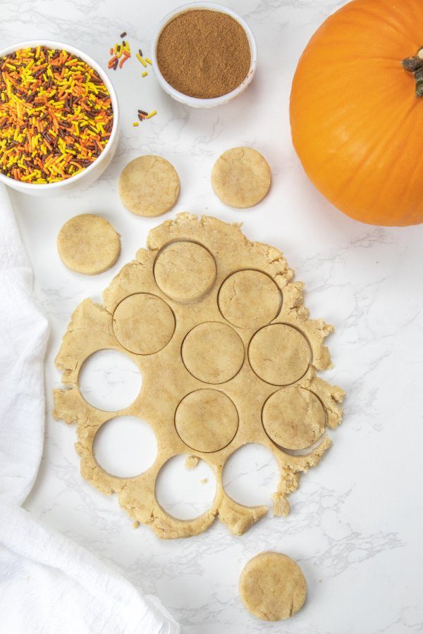 rolled out sugar cookie dough on marble counter 