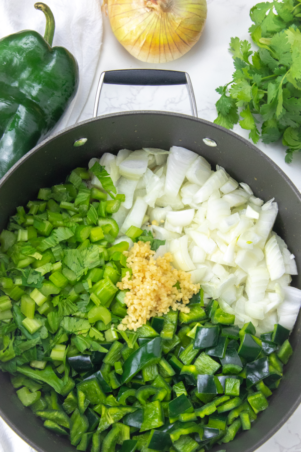 veggies in pot with herbs around it 