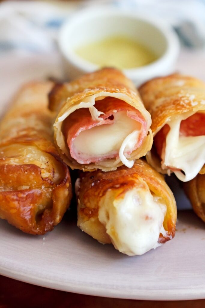 salami cheese rolls stacked on plate 