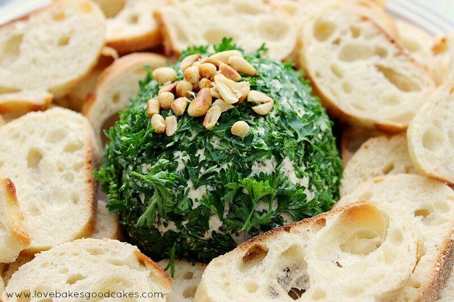 pesto flavor cheese ball with bread around it 