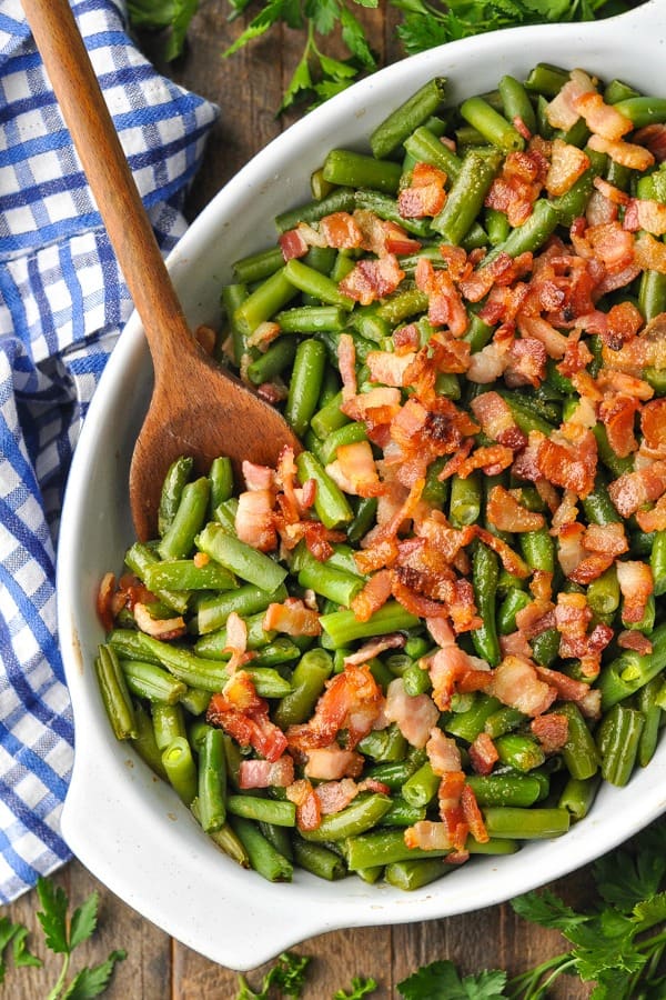 green beans in a casserole dish with bacon on top 