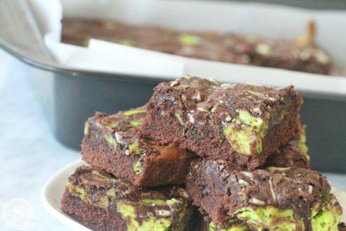 stacked mint chocolate cheesecake brownies on tray