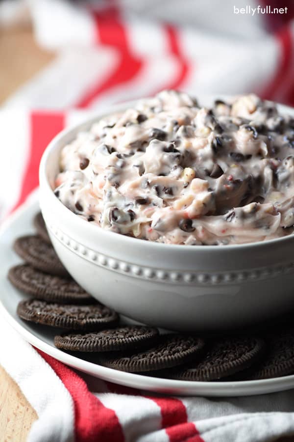 peppermint bark dip in a bowl with cookies around it 