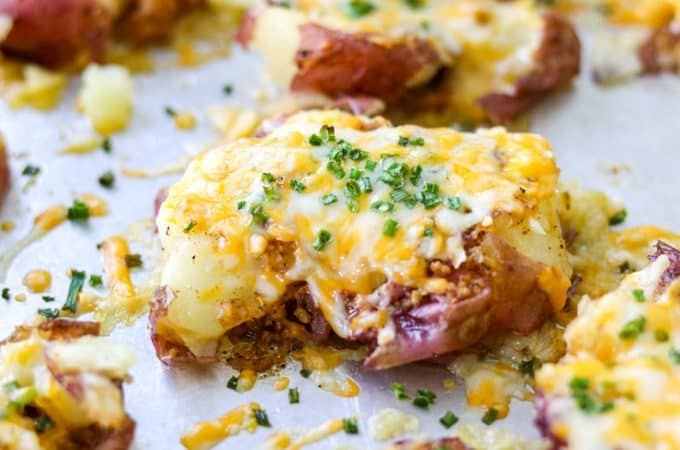 smashed potatoes on baking sheet topped with cheese 