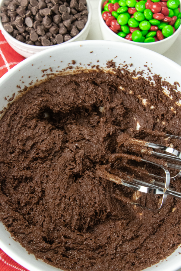 brownie batter in bowl with mixing sticks 