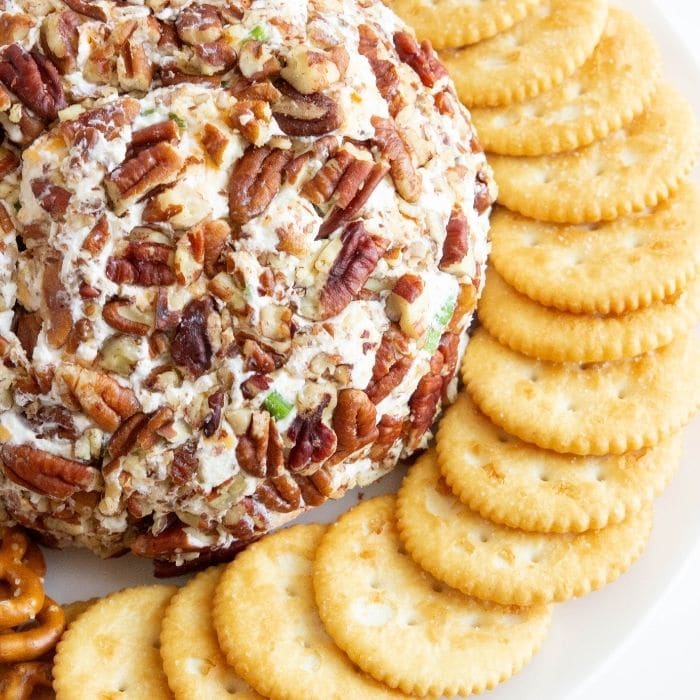 cheeseball on plate with crackers around it 
