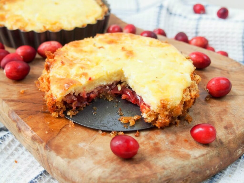 cheese cranberry tart on wooden cutting board 