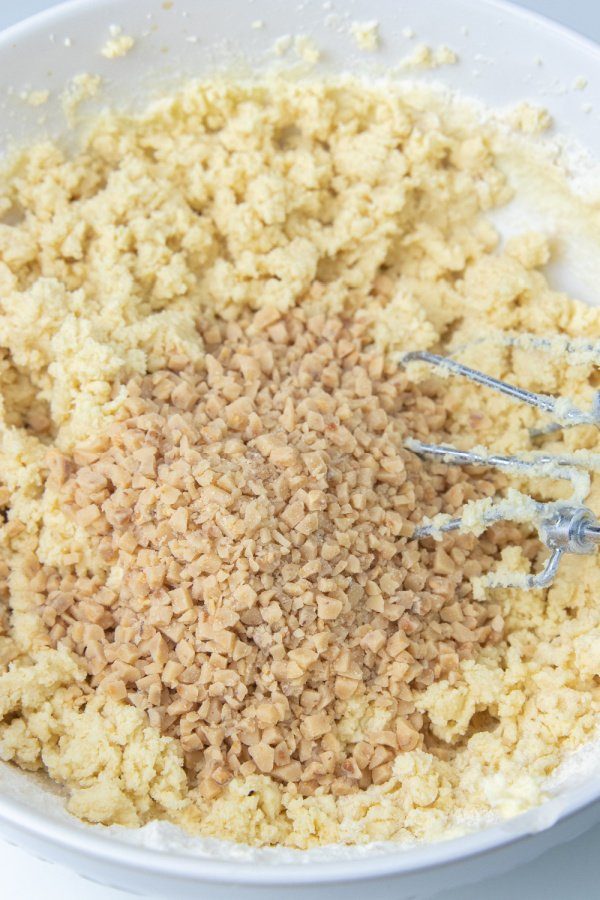 toffee bits in cookie batter in a bowl 