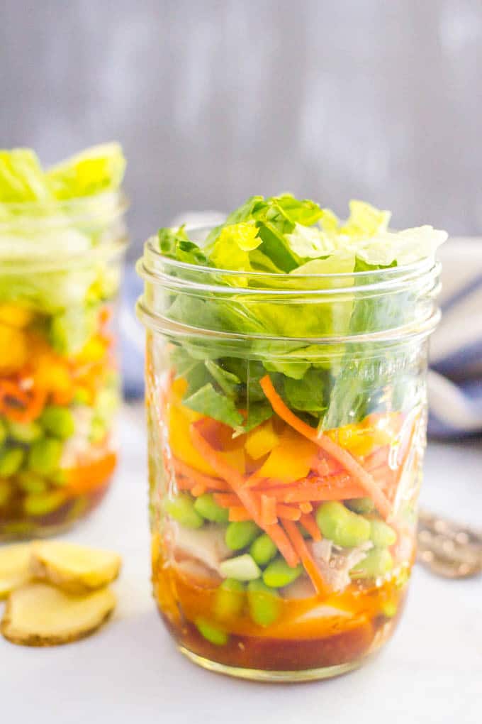 asian chicken salad in mason jars on counter 