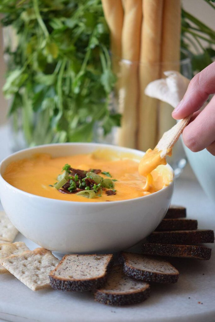 cheese dip on cracker in white bowl 
