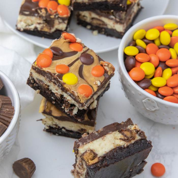 Brownie Reese's Cheesecake Bars is a layered brownie with two types of Reese's inside. A peanut butter and chocolate lovers dessert idea! A must make peanut butter brownie with cheesecake. #passion4savings #peanutbutter #brownie #cheesecake #easy #dessert Reese's Brownies stacked brownies