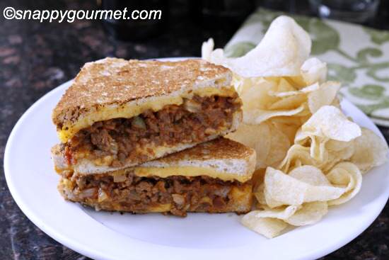 sloppy joe cheese sandwich on plate with chips 
