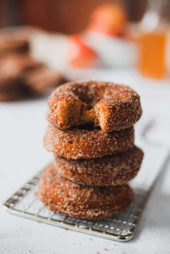 stacked apple cider donuts on baking rack