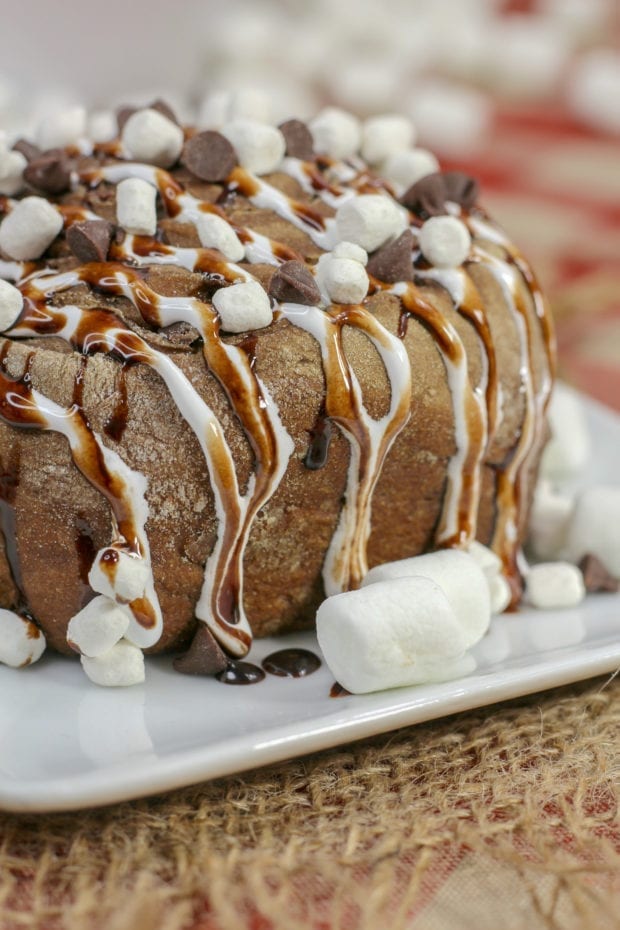 cinnamon roll on plate drizzled with marshmallows, chocolate, etc. 