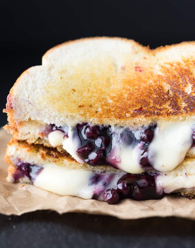 blueberry and brie grilled cheese on cutting board oozing out 