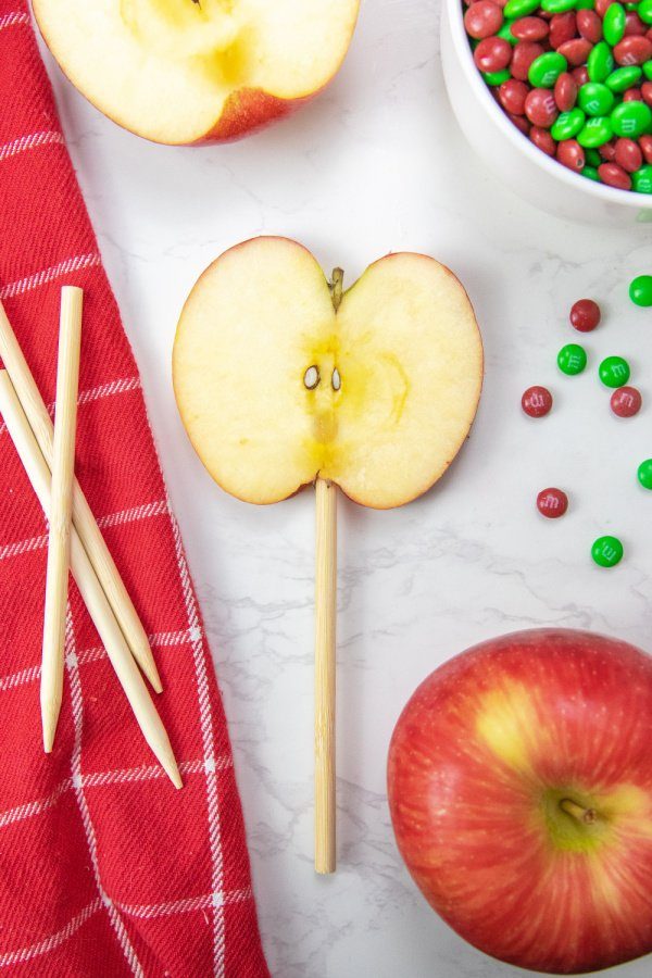 Christmas Chocolate Covered Apple Slices are a simple and easy no bake Christmas treat. Sliced apples decorated and ready to eat in minutes. #passion4savings #apples #dessert #christmas #sliced #dipped #chocolate #chocolatecovered #nobake #kidfriendly apple on a stick