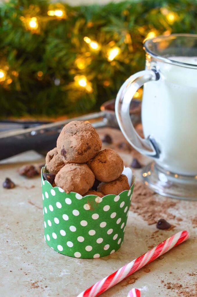 truffle balls in a container with christmas tree behind it 