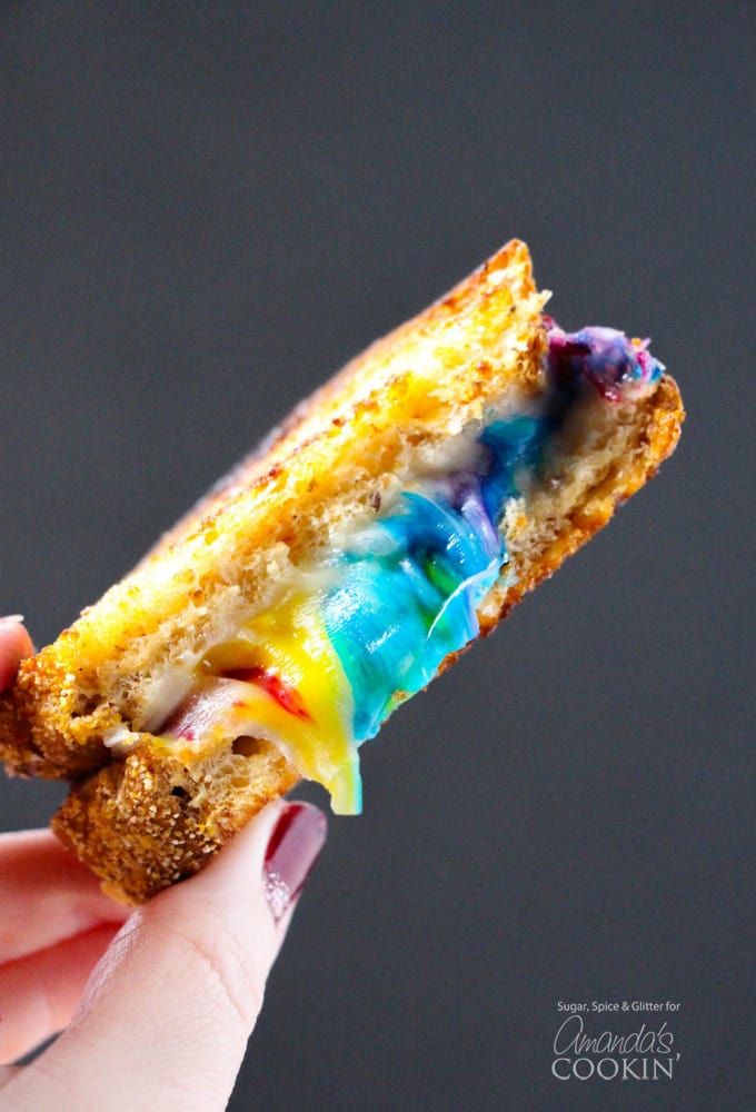 sliced rainbow grilled cheese in hand 