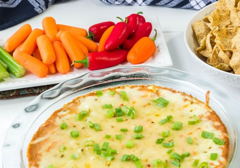 Texas trash dip in baking dips with veggies behind it 