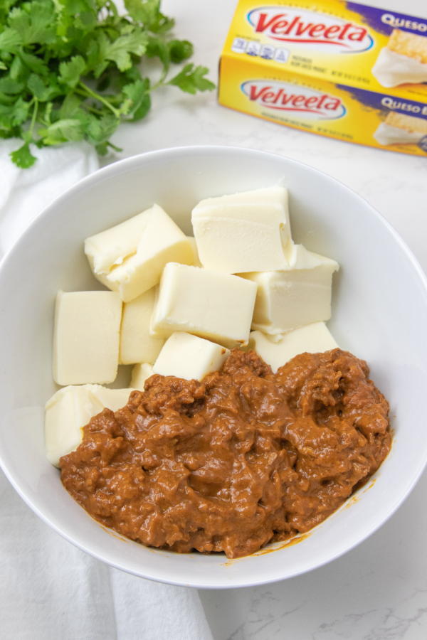velveeta cubes and chili in a white bowl on counter 