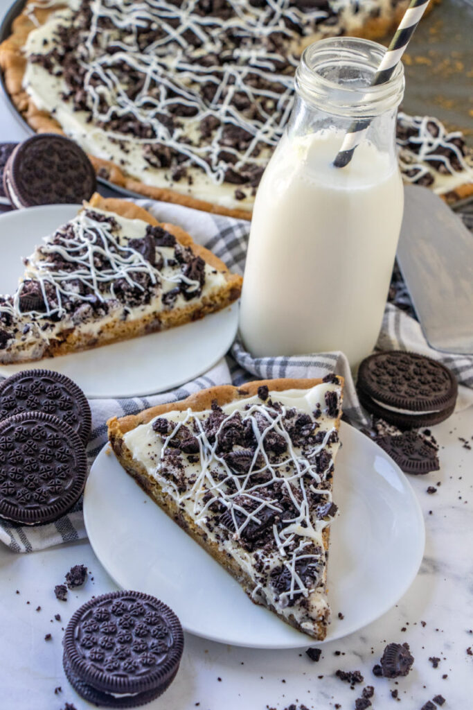 cookie and cream pizza on plates with milk by it 