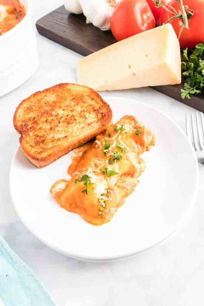manacotti pasta on plate with garlic bread 