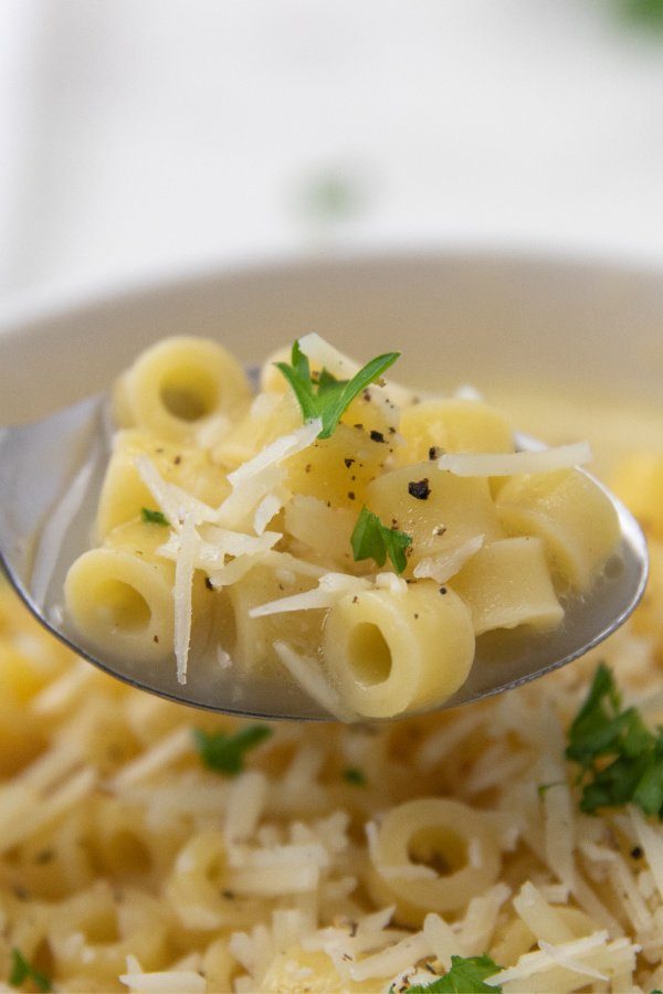 spoon with pasta soup in it 