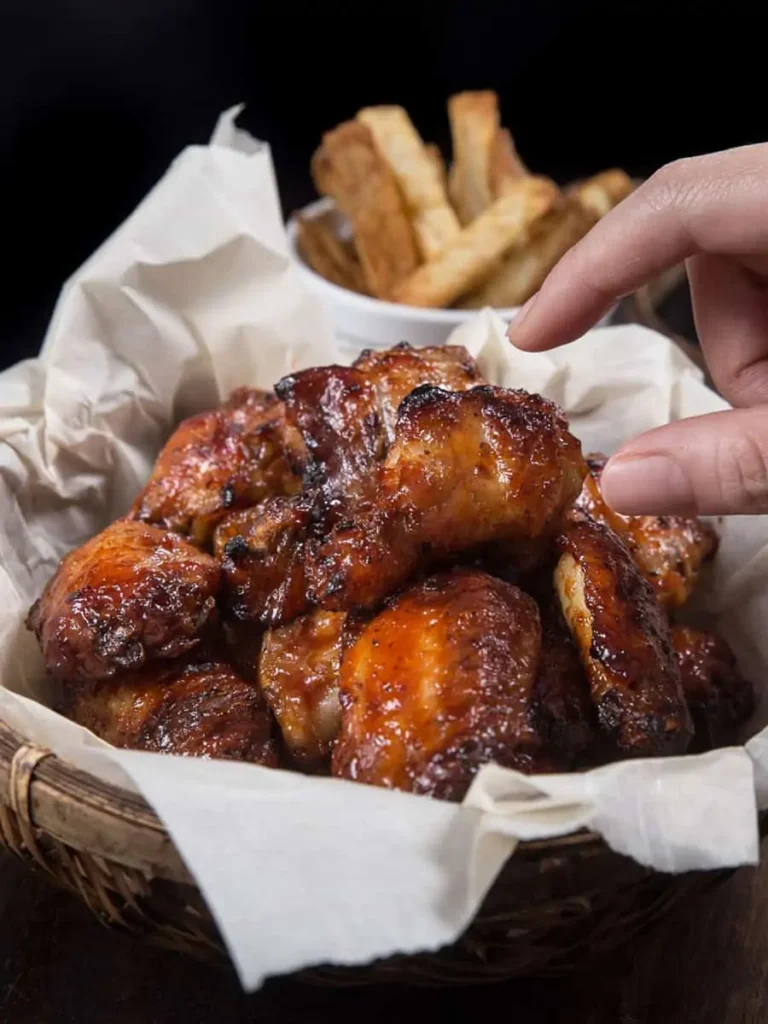 reaching for a chicken wing in basket 