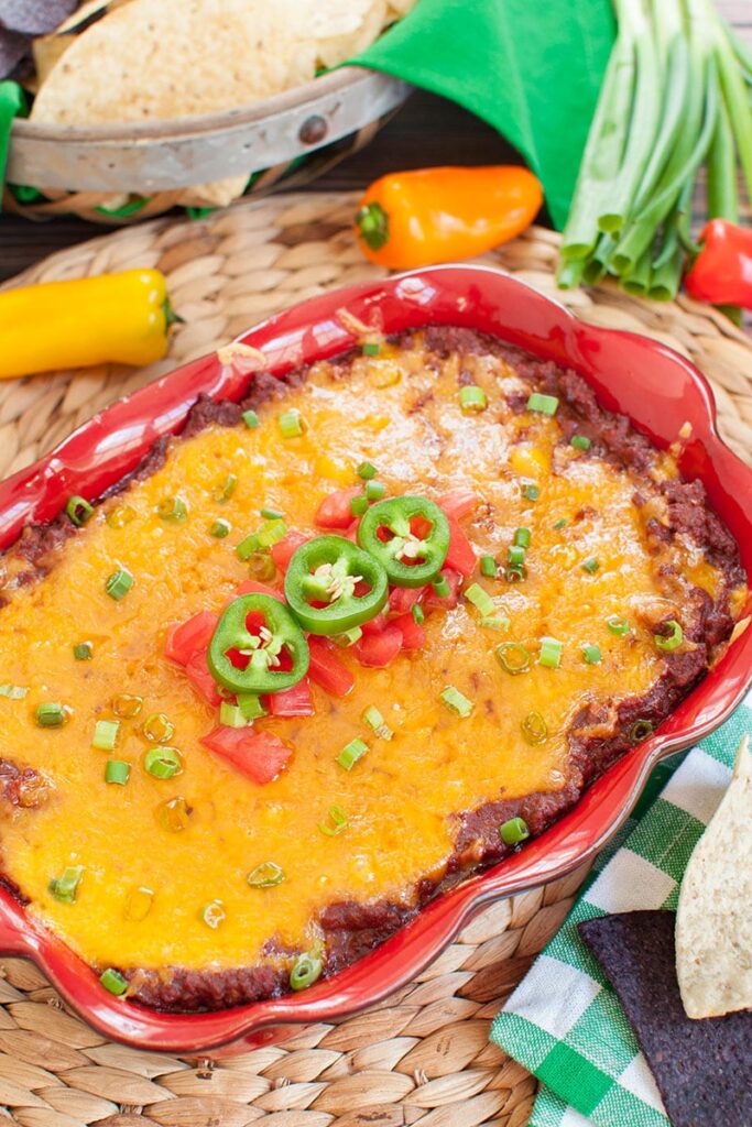 chili cheese dip in a casserole dish with jalapeno slices on top 