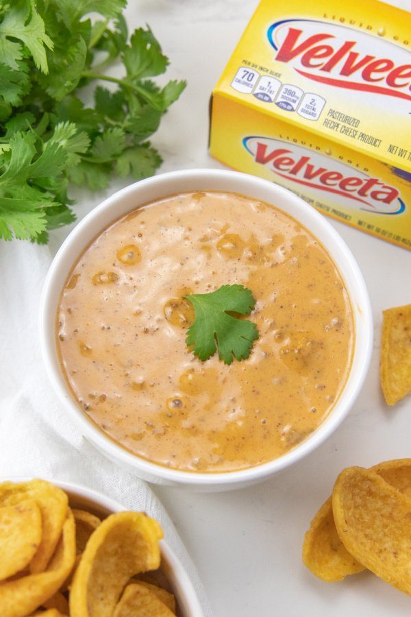 2 Ingredient Game Day Chili Dip! This easy appetizer recipe takes 5 minutes to make and is so addictive. A cheesy chili dip you got to try. #passion4savings #chilidip #gameday #superbowl #appetizer #recipe #easy #quick #5minute #budgetfriendly chili dip in bowl on counter with velveeta behind it
