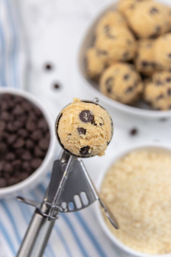Keto cookie dough fat bombs is a great way to fuel your body and enjoy a sweet treat to break up the day. Simple ingredients is all it takes. #passion4savings #keto #cookiedough #fatbomb #ketorecipe #easy #best #homemade #fromscratch cookie scoop with fat bomb in it