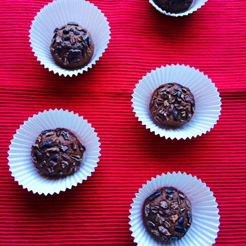 energy bites in mini muffin papers on red table 