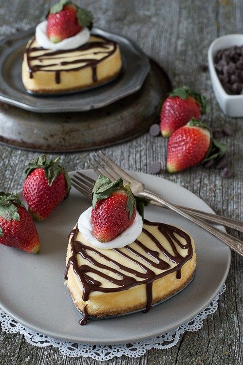 heart shaped cheesecake on plate with strawberry on top 