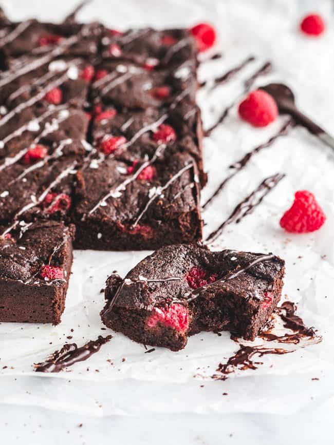 bite taken out of raspberry brownie on marble counter 