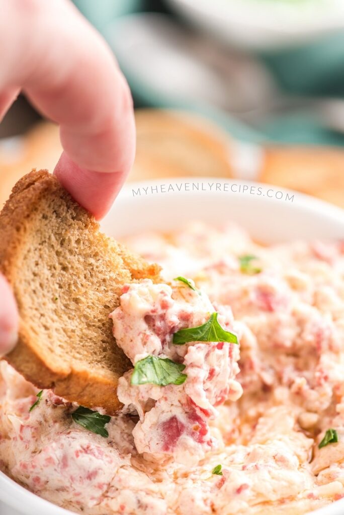 reuben dip with baguette dipping in it 