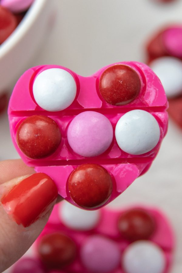 Check out this easy Valentine Pop It Candy for Kids! Use your heart shaped pop it to make a DIY chocolate treat. So easy, no bake, and fun! #passion4saving #popit #valentine #valentinesday #chocolate #diy #easy #fun #forkids heart chocolate in hand