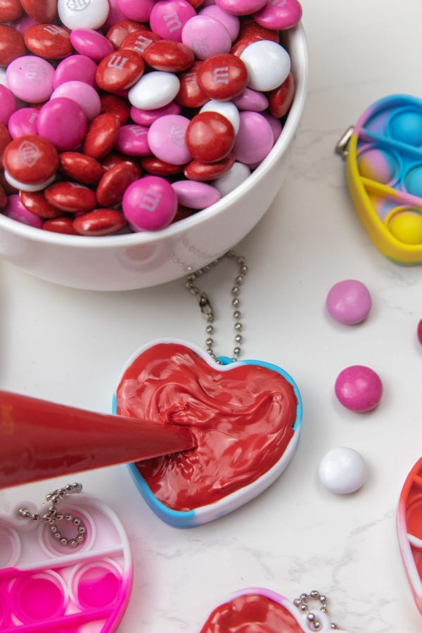 Check out this easy Valentine Pop It Candy for Kids! Use your heart shaped pop it to make a DIY chocolate treat. So easy, no bake, and fun! #passion4saving #popit #valentine #valentinesday #chocolate #diy #easy #fun #forkids how to make valentine's day chocolates