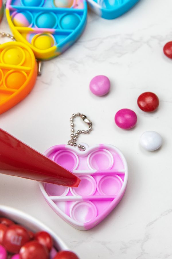 Check out this easy Valentine Pop It Candy for Kids! Use your heart shaped pop it to make a DIY chocolate treat. So easy, no bake, and fun! #passion4saving #popit #valentine #valentinesday #chocolate #diy #easy #fun #forkids pop it chocolate mold