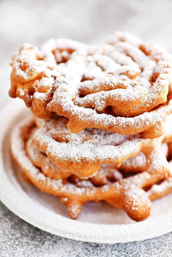 stack of funnel cakes with powdered sugar 