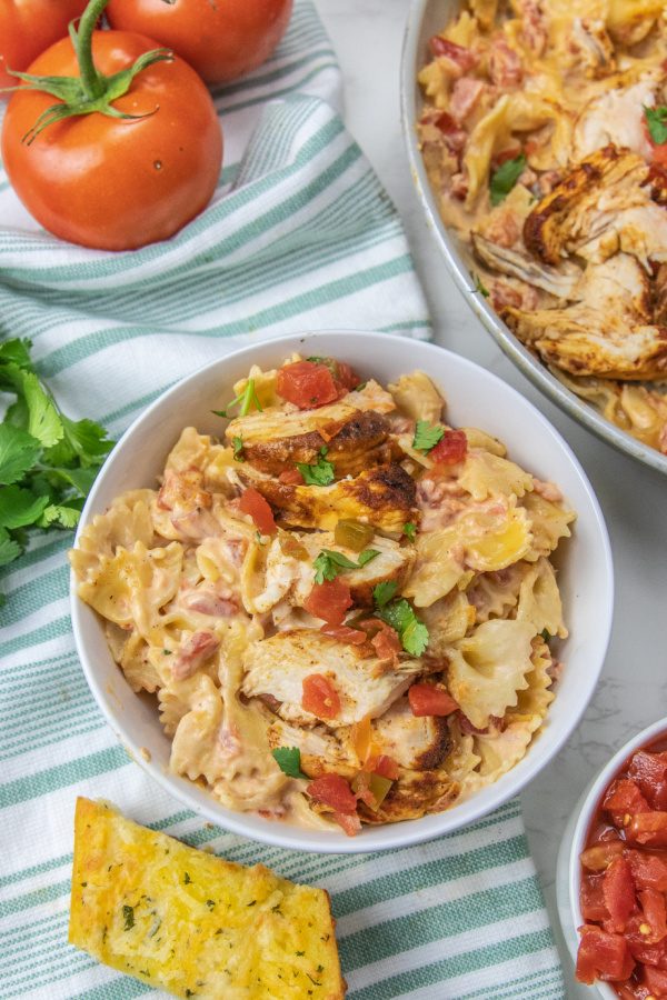 mexican chicken alfredo in bowl with garnishes around it on table 