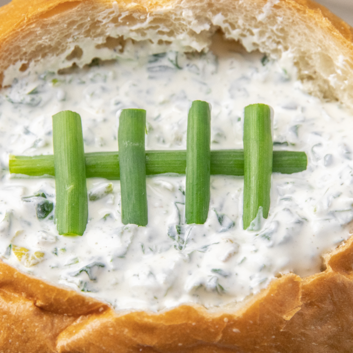 bread bowl dip close up picture of green onion laces 
