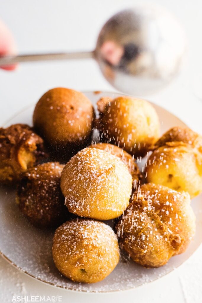 fried cookie dough balls on plate dusting with sugar 