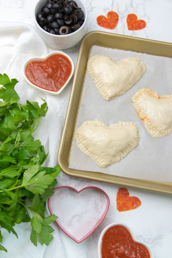 Heart Shaped Calzones are a simple and easy Valentine's day dinner idea. Kid friendly and loaded with pizza flavor in each cheesy bite. #passion4savings #calzones #valentinesday #heart #heartshaped #dinner #kidfriendly #easy #quick #fun homemade calzones