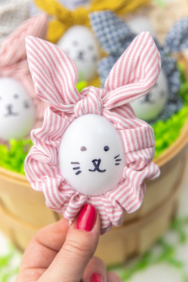 holding easter egg in hand with scrunchie around it 