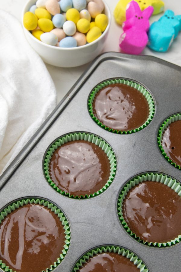 Peeps Easter Bunny Cupcakes are a chocolate cupcake with coconut and a marshmallow frosting. Top it off with a Peep, perfect for Easter! #passion4savings #peeps #easter #cupcakes #dessert #marshmallow #easy #cute #festive #fun #holidaydessert view of raw cupcake batter in cupcake pan