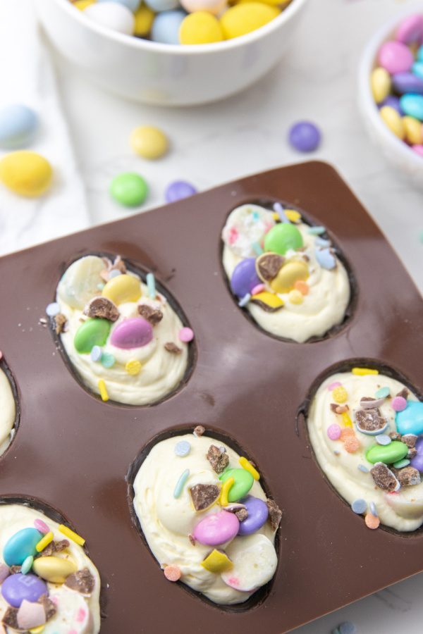 Loaded Cheesecake Easter Eggs are a chocolate candy egg filled with cheesecake and topped with Easter candy. An easy make ahead Easter treat. These fun Easter egg desserts will steal the show. #passion4savings #easter #eggs #dessert #nobake #cheesecake #howto #makeahead Desserts for Easter