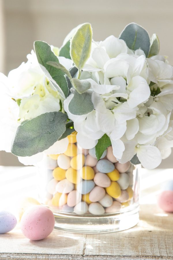 This Easter Candy Centerpiece takes 5 minutes to make. A simple and elegant Easter centerpiece that uses candy and faux flowers. Learn how to dress up your home in minutes for Easter. #passion4savings #easter #centerpiece #easy #quick #fauxflowers #flowers #candy Easter centerpiece