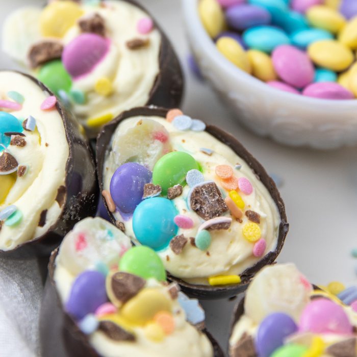 Loaded Cheesecake Easter Eggs are a chocolate candy egg filled with cheesecake and topped with Easter candy. An easy make ahead Easter treat. These fun Easter egg desserts will steal the show. #passion4savings #easter #eggs #dessert #nobake #cheesecake #howto #makeahead Easter Eggs with candy on top