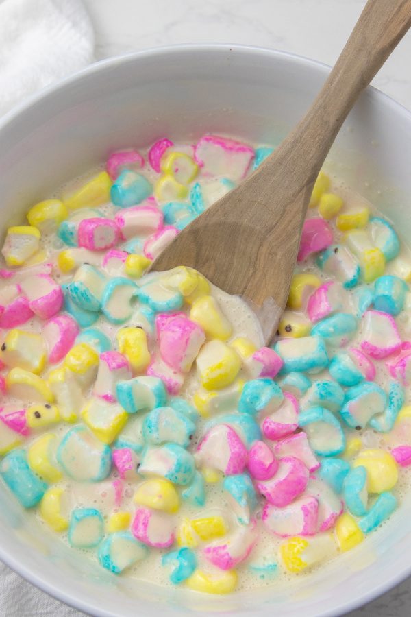 Easter peeps pancakes are a fluffy pancake filled with bits of peeps. This is a marshmallow pancake perfect for Easter morning breakfast. #passion4savings #easter #pancakes #peeps #tradition #spring #morning #eastermorning Peep Pancake batter in a bowl with wooden spoon